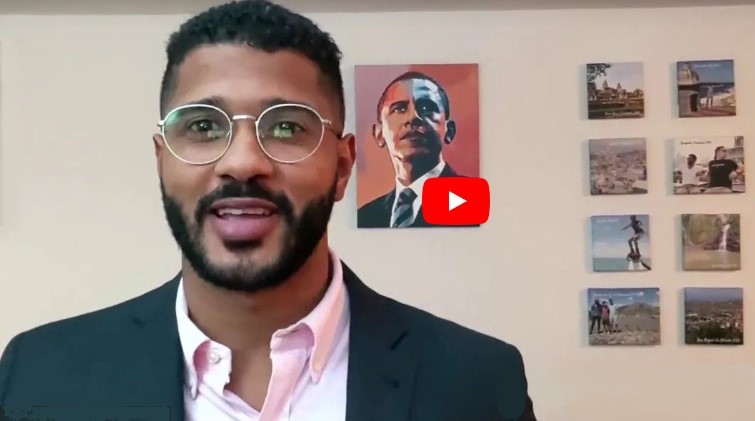 A young man on video with a picture of Barack Obama in the background