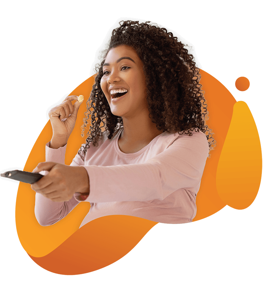 Smiling woman holding a TV remote and eating popcorn against an orange abstract background graphic.