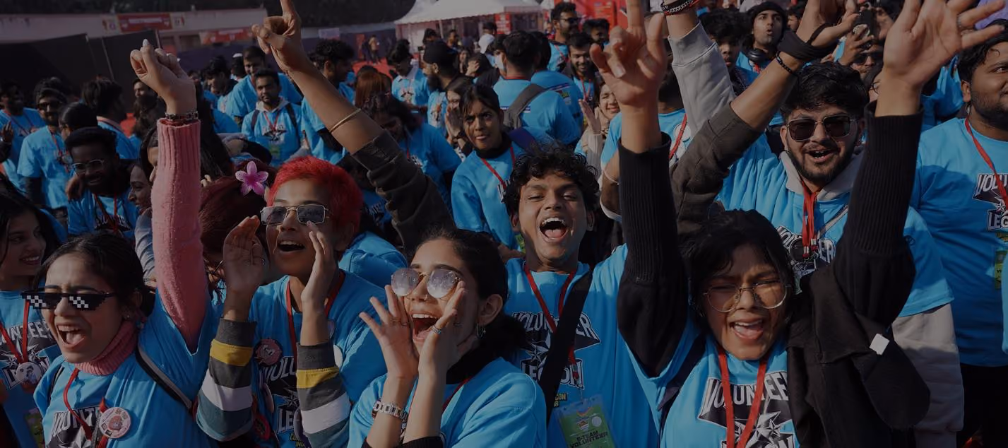 Crowd of fans in blue Comic Con India T-shirts cheering with hands raised