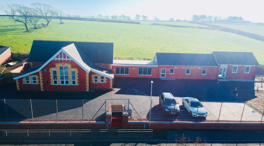 An aerial view of Cywion Bach nursery, showing the main red-brick building and the ca park