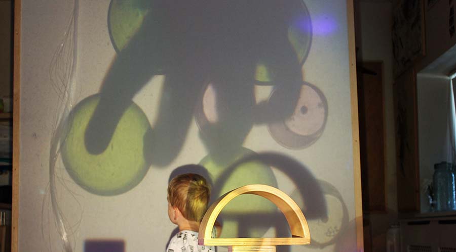 Child playing with a projector, in a setting