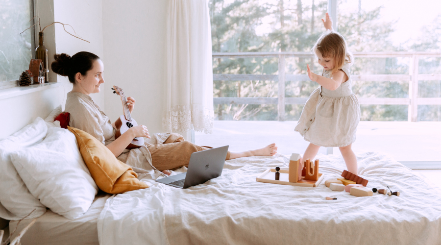 A parent and a preschooler enjoy making music at home