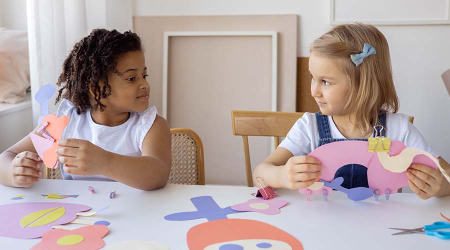 2 Early Years girls doing handicrafts with colour papers