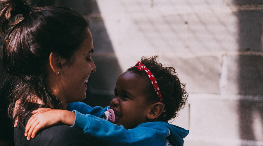 An early years educator embraces a child