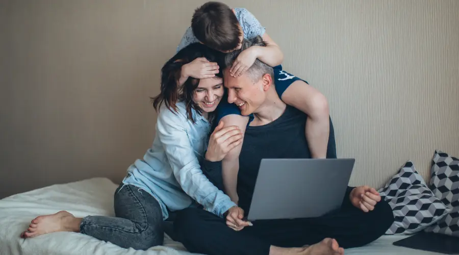 A photograph of an early yeas child climbing on their parents.