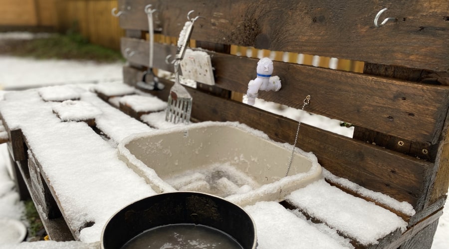 A mud kitchen at Deerness Valley, covered in snow.