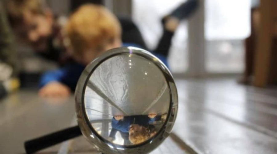 Kids playing with a magnifying glass