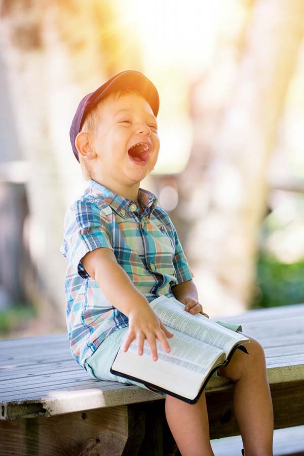 A child reading the Hungry Caterpillar story and laughing