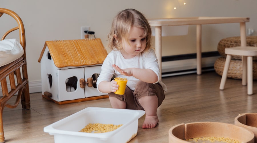 Girl holding yellow plastic cup full of macaroni