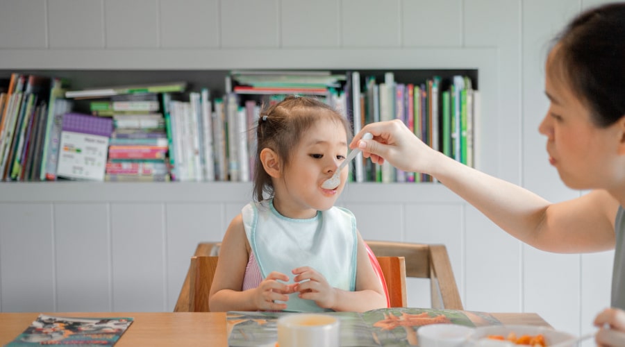 Mother feeding daughter
