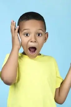 shocked boy holding phone to ear