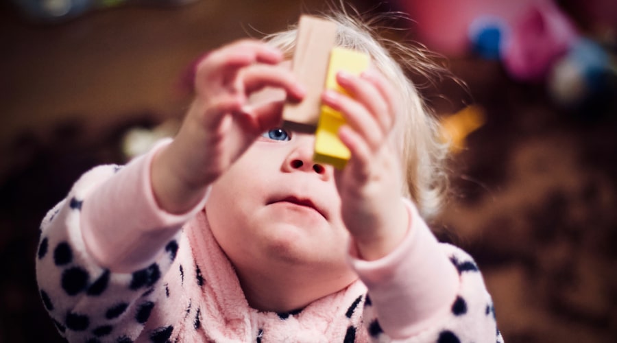 A young child holding up some blocks