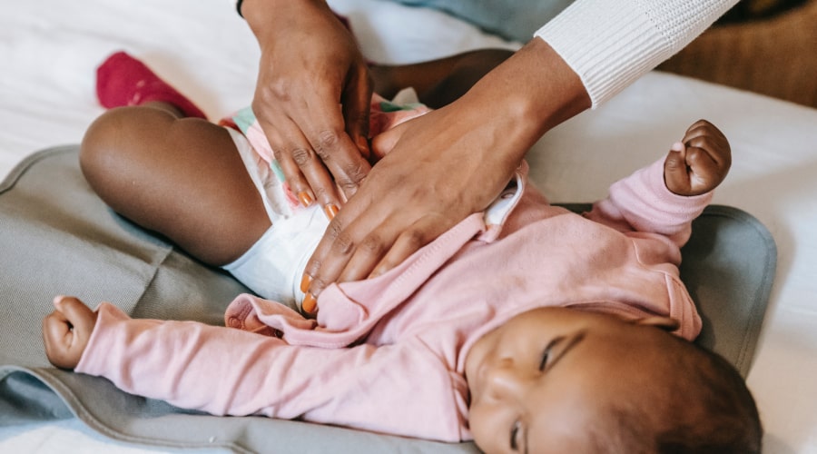 An Early Years educator dressing a baby