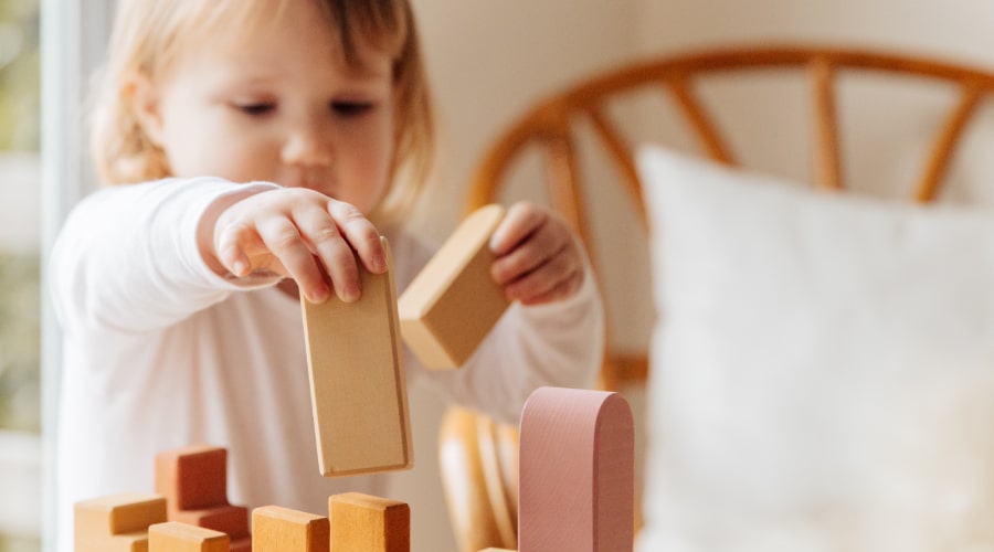 Little girl playing with wooden blocks
