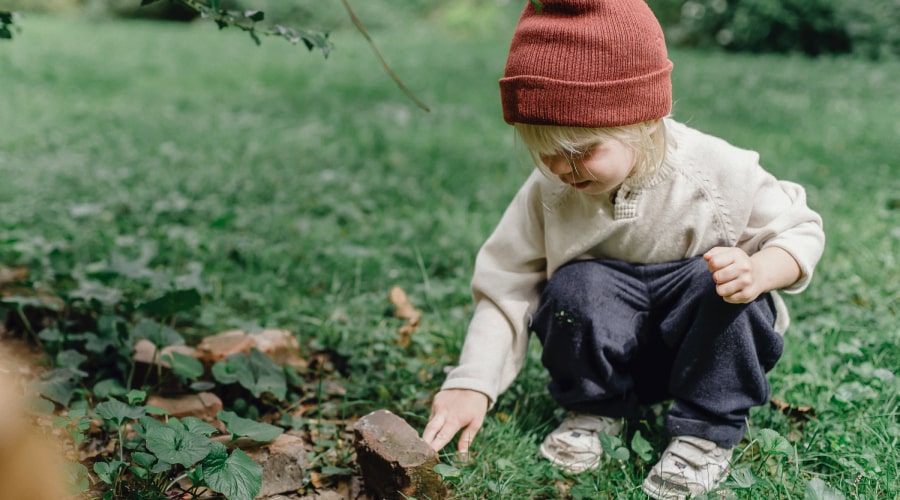 Interested little boy exploring stone