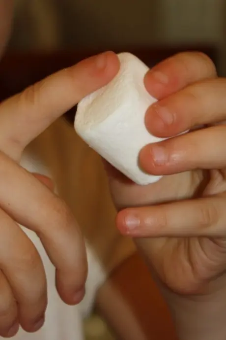 Child playing with marshmallows
