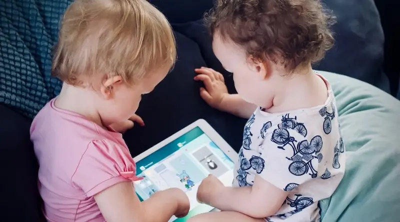 Two kids playing with a tablet