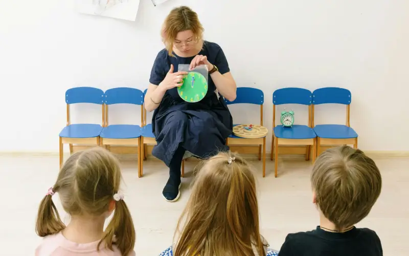 preschool teacher teaching children how to tell time