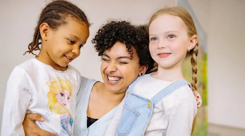 mother smiling with her two daughters 