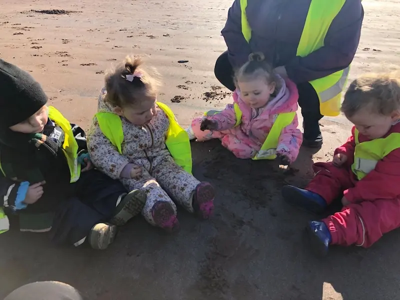 Four children from Acorns Pre-school enjoy an outing to the beach