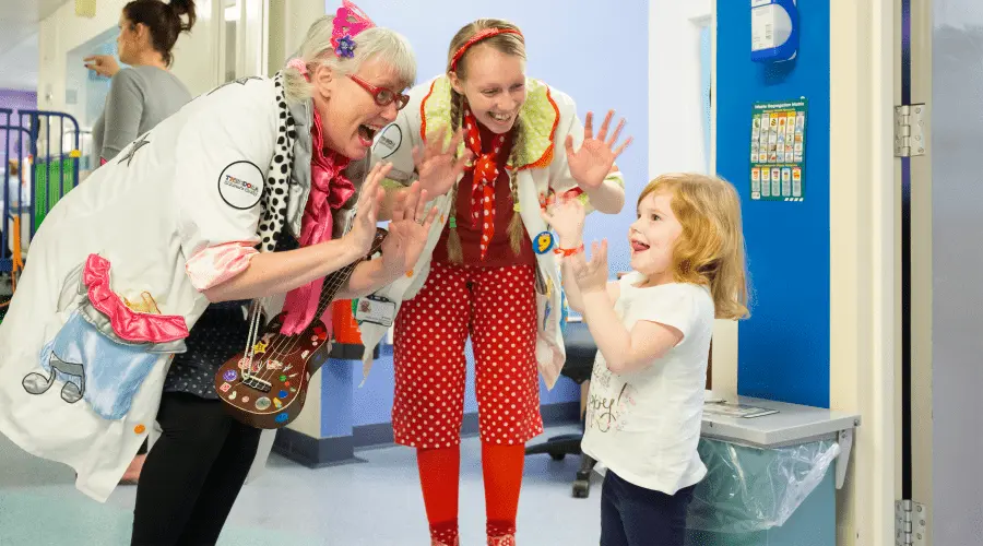 Dr Fab and Dr Dotty dance with a young patient on a hospital ward.