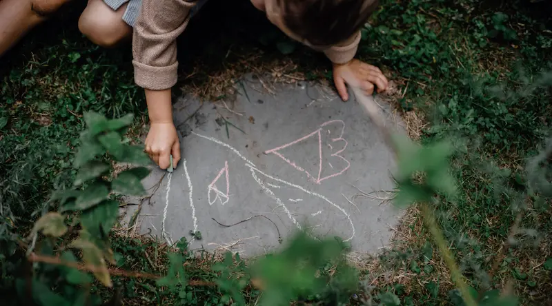 Girl drawing with choke on rock