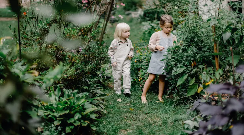 Two girls walking in a green garden