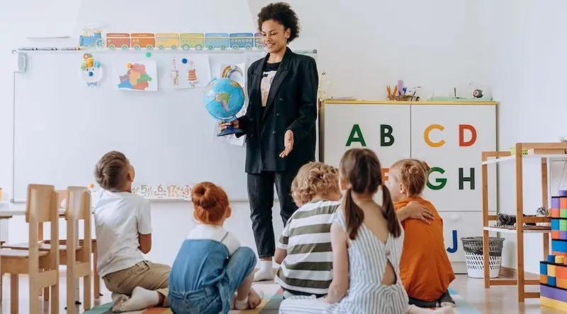An early years practitioner teaching children in their setting