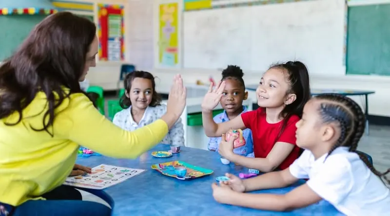 A teacher and a girl doing a high five