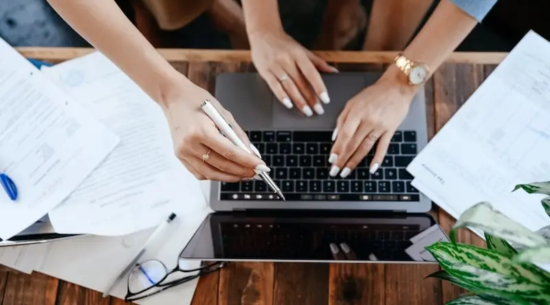 Persons pointing out a laptop