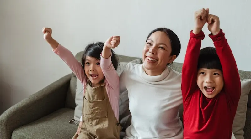 Woman with two kids on sofa smiling