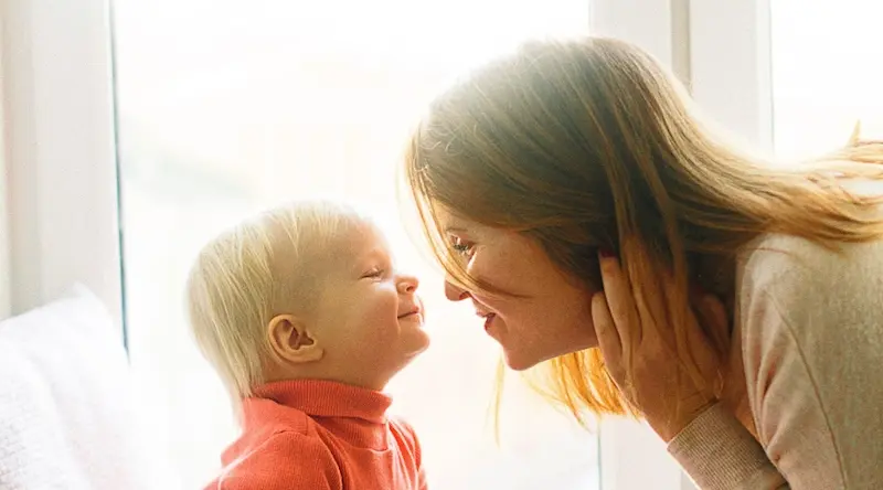 Woman smiling together with her little child
