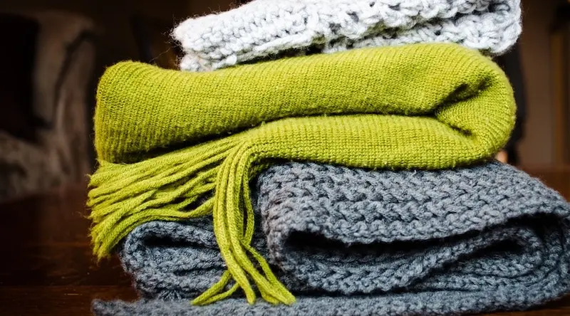 A pile of grey and green blankets