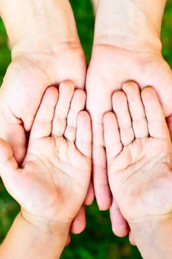 Two pairs of hands on top of each other