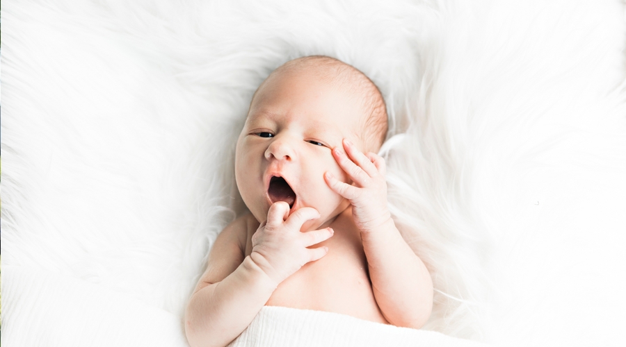 baby in fluffy blanket yawning 