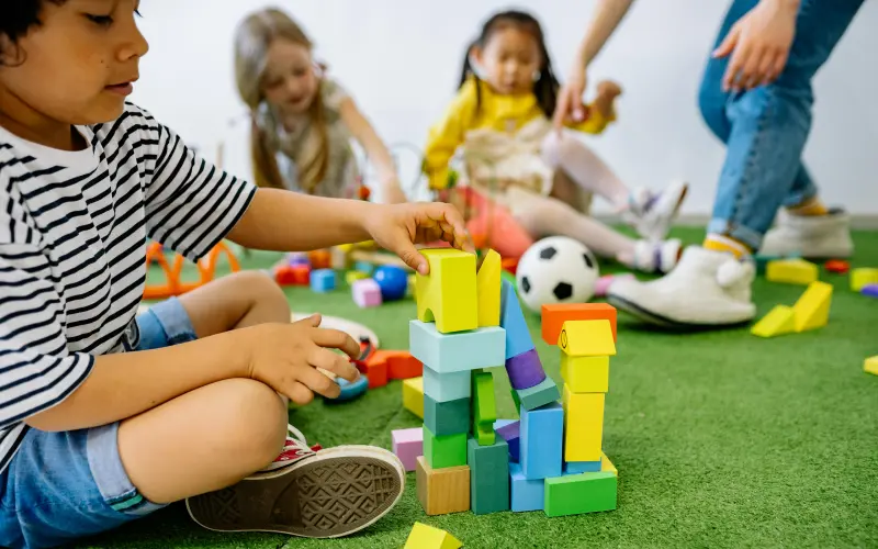 young boy playing with blocks in the preschool classroom