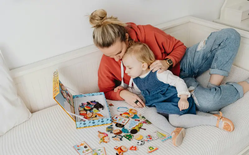 mom playing with toddler on couch