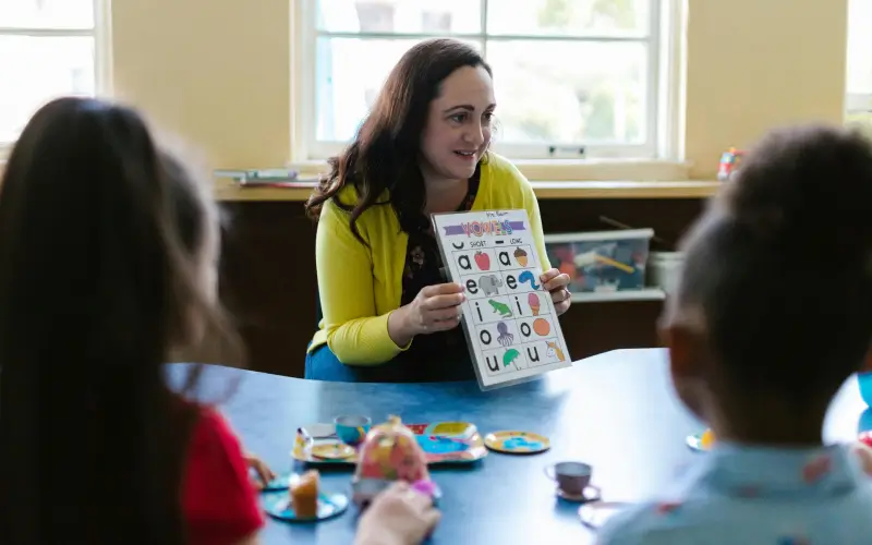 preschool teacher engaging with the children teaching them their letters