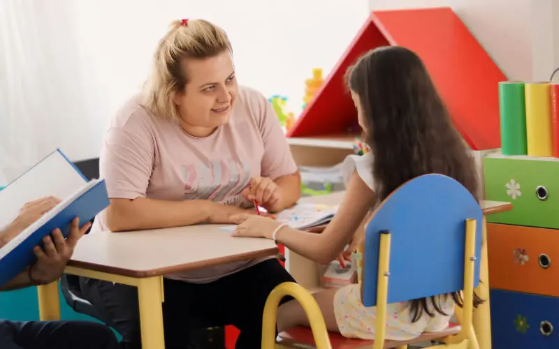 teacher and young child in preschool