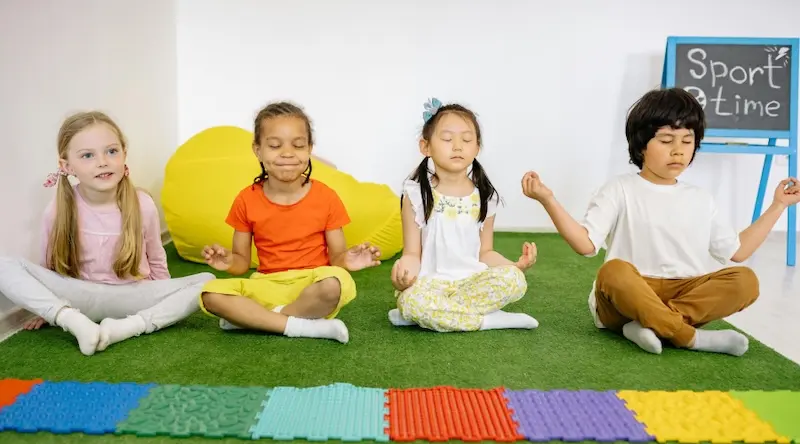 Kids meditating on green