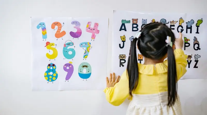 a preschool girl learning her letters and numbers