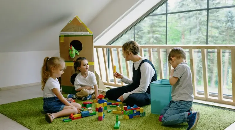 preschoolers playing on floor with teacher