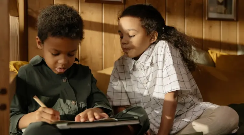 two boys looking at worksheet with pencil