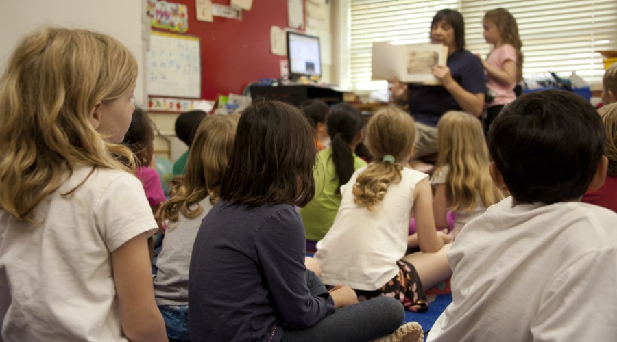 woman teaching a group of sitting children