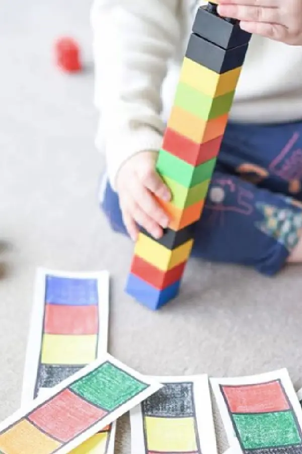 Kid stacking colourful cubes