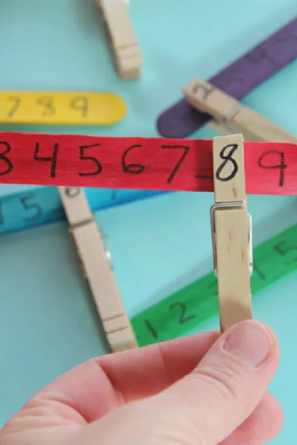 Hand holding a clipper with the number 8 drawn on it