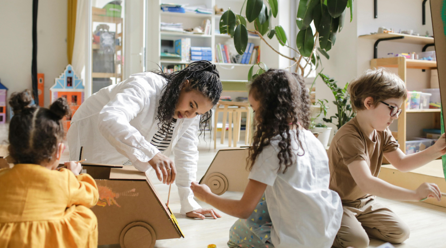 teacher panting and playing with children in preschool