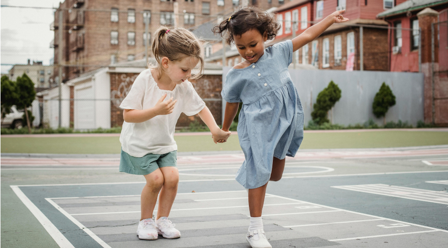 two young girls playing hopscotch
