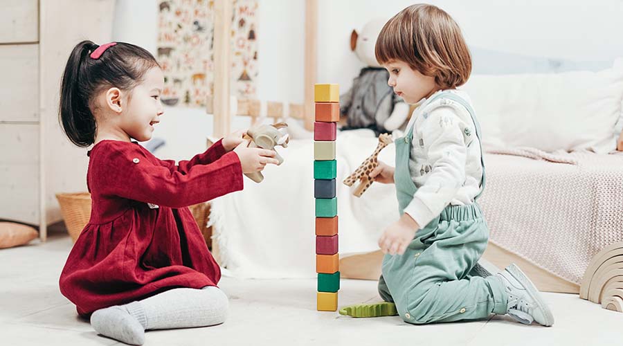 Two children build a tower out of blocks together