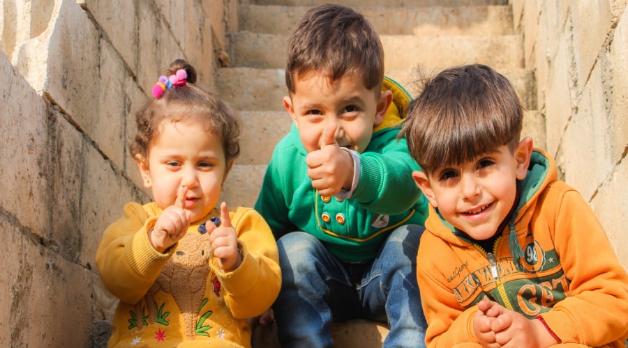 Three children sitting on stairs